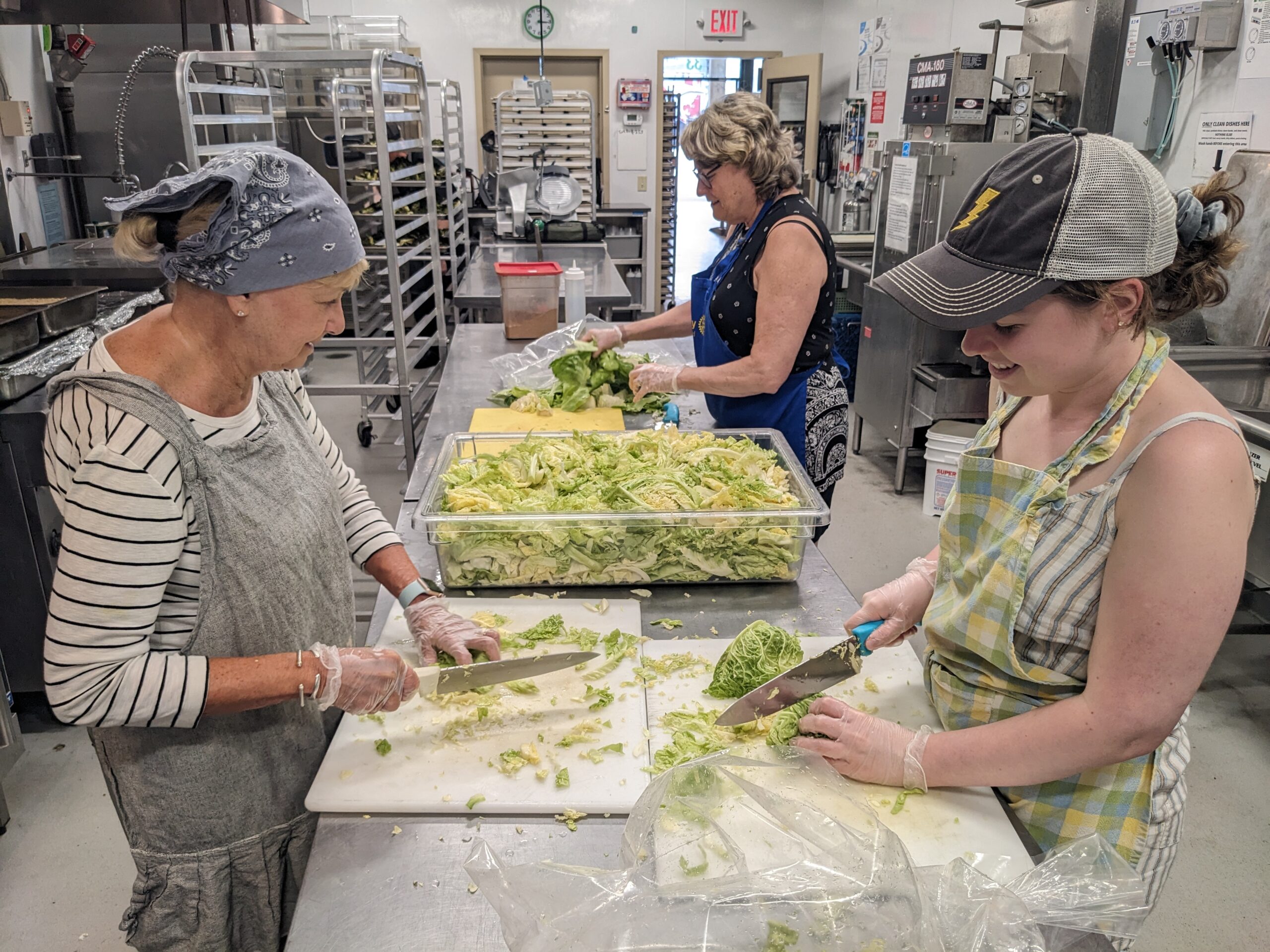 Volunteers chopping lettuce for prepared meals at Open Table