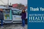 Two female volunteers outside our refrigerated van which is filled with food for deliveries