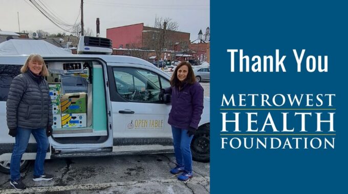 Two female volunteers outside our refrigerated van which is filled with food for deliveries