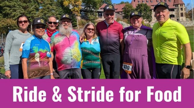 Eight members of the Open Table Ride and Stride for food team. Some in Open Table hats. Some in bike rider jerseys. A purple banner at the bottom has white letters reading "Ride & Stride for Food"